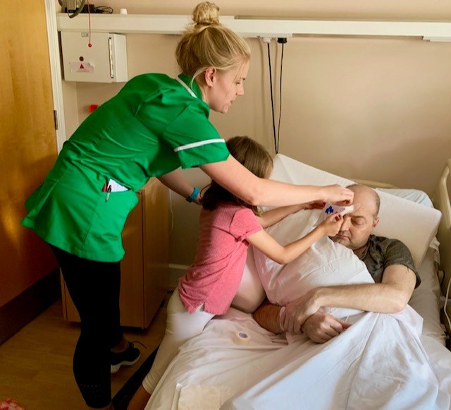 Ellie helping a Hospice Nurse provide care to Simon