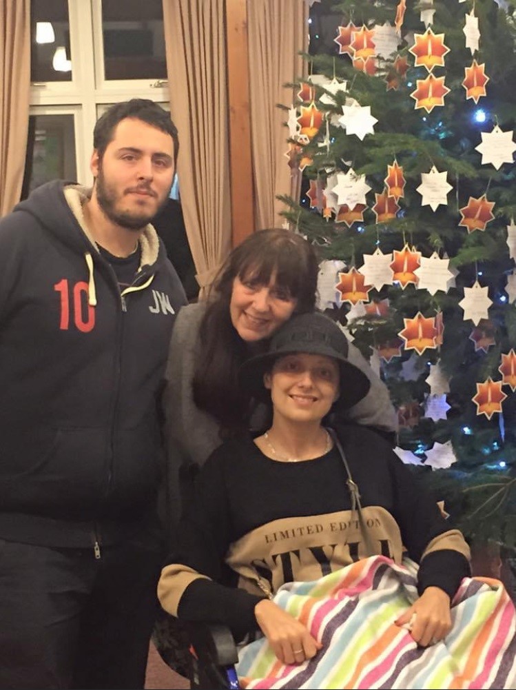 Patient and Family in front of Christmas tree