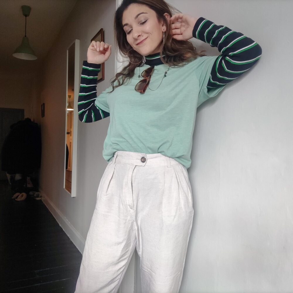 Safia in white linen trousers and a turtleneck with a baggy tee on top