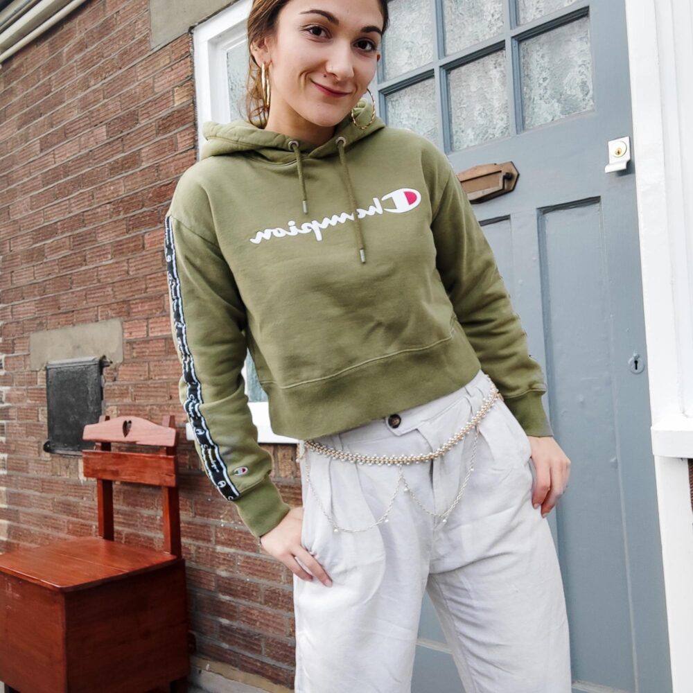 Safia in linen trousers and green Champion hoodie