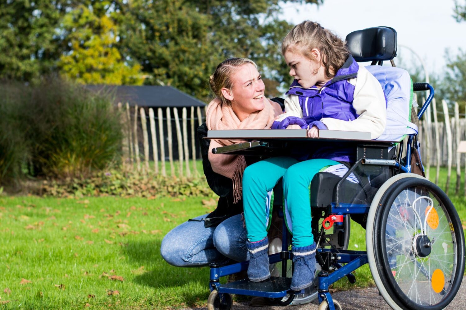 female child in wheelchair and adult female outside